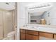 Bright bathroom features a vanity with wood cabinets, a shower with a glass door, and a large mirror at 6237 E Boston St, Mesa, AZ 85205