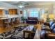 Bright living room with bay windows, ceiling fan, hardwood floors, and breakfast bar at 6237 E Boston St, Mesa, AZ 85205