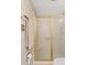 Shower stall with gold frame and glass door, neutral tile surround, towel rack with decorative detail and rolled towel at 6237 E Boston St, Mesa, AZ 85205