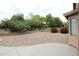 Landscaped backyard with decorative rock feature and a concrete patio at 7151 W Lamar Rd, Glendale, AZ 85303