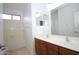 Well-lit bathroom featuring double sinks with wooden cabinets and a tub with tile surround at 7151 W Lamar Rd, Glendale, AZ 85303