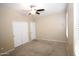Bright bedroom featuring neutral paint, a ceiling fan, and a closet with white bi-fold doors at 7151 W Lamar Rd, Glendale, AZ 85303