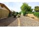 Spacious backyard featuring stone landscaping, mature trees, storage shed, and walkway at 7521 S College Ave, Tempe, AZ 85283
