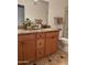 Bathroom vanity with wood cabinets, granite countertop, mirror, sink, and toilet at 7521 S College Ave, Tempe, AZ 85283