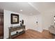 Hallway with console table, clean white walls, and wood flooring at 7521 S College Ave, Tempe, AZ 85283