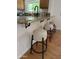 Granite countertop with three bar stools in kitchen area with hardwood floors and stainless steel faucet at 7521 S College Ave, Tempe, AZ 85283