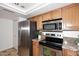 Kitchen features stainless steel appliances, granite countertops, and light wood cabinetry at 7521 S College Ave, Tempe, AZ 85283