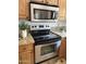 Kitchen features stainless steel oven, cooktop, granite counters, and microwave above at 7521 S College Ave, Tempe, AZ 85283
