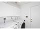 Clean and functional laundry room with modern washer and dryer and ample storage cabinets at 7521 S College Ave, Tempe, AZ 85283