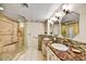 Bathroom with double sinks, granite counters, decorative tile, and luxurious walk-in shower at 7700 E Gainey Ranch Rd # 124, Scottsdale, AZ 85258