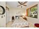 Cozy bedroom with tiled floor, a ceiling fan, a large window, and a double-door closet at 7700 E Gainey Ranch Rd # 124, Scottsdale, AZ 85258