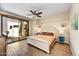 Bright bedroom featuring a ceiling fan, sliding glass doors, and wood-look flooring at 7700 E Gainey Ranch Rd # 124, Scottsdale, AZ 85258
