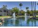 Beautiful condo community featuring a sparkling lake with fountains, palm trees, and lush landscaping under a clear blue sky at 7700 E Gainey Ranch Rd # 124, Scottsdale, AZ 85258