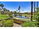 Community pond showcasing lush landscaping, mature palm trees, and building exteriors at 7700 E Gainey Ranch Rd # 124, Scottsdale, AZ 85258