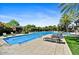 Community pool area with lounge chairs, cabanas, lush landscaping, and clear blue water at 7700 E Gainey Ranch Rd # 124, Scottsdale, AZ 85258