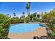 Community pool surrounded by greenery, lounge chairs, and a modern building at 7700 E Gainey Ranch Rd # 124, Scottsdale, AZ 85258