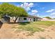 Large backyard featuring a covered patio, mature trees, and tall privacy fence at 8207 W Planada Ln, Peoria, AZ 85383