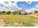 Large backyard featuring a covered patio, spacious lawn, and tall privacy fence at 8207 W Planada Ln, Peoria, AZ 85383