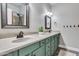 Bathroom featuring double sinks, a framed mirror, vanity lights, and green cabinets at 8207 W Planada Ln, Peoria, AZ 85383