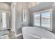 Bright bathroom features a soaking tub, plantation shutters and backyard access at 8207 W Planada Ln, Peoria, AZ 85383