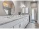 Bathroom features a double sink vanity, granite countertop and custom mirrors at 8207 W Planada Ln, Peoria, AZ 85383