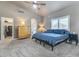 Bedroom featuring a ceiling fan, large bed, dresser, and a doorway to the ensuite bathroom at 8207 W Planada Ln, Peoria, AZ 85383