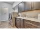 Well-equipped laundry room with modern washer and dryer, ample counter space, and convenient storage cabinets at 8207 W Planada Ln, Peoria, AZ 85383