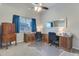 A spacious office featuring dual desks, a ceiling fan, and a coordinating wood armoire at 8207 W Planada Ln, Peoria, AZ 85383