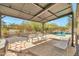 Relaxing backyard featuring a covered patio, pool, and well-maintained desert landscaping at 8465 W Andrea Dr, Peoria, AZ 85383