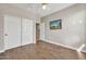 Bright bedroom with laminate wood flooring, double door closet, and neutral walls at 8465 W Andrea Dr, Peoria, AZ 85383