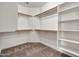 Spacious walk-in closet with wood racks, shelving, and neutral carpet at 8465 W Andrea Dr, Peoria, AZ 85383