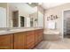 Bright bathroom with dual sinks, separate tub, walk-in shower, and decorative cactus wall art at 8647 W Lariat Ln, Peoria, AZ 85383