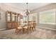 Dining room with a glass table, wooden chairs, a china cabinet, and natural light from the windows at 8647 W Lariat Ln, Peoria, AZ 85383