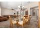 Dining room with seating for six, a glass table, chandelier, and open access to the living room at 8647 W Lariat Ln, Peoria, AZ 85383