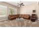 Bright living room featuring a comfortable tan sectional sofa, ceiling fan, and modern décor at 8647 W Lariat Ln, Peoria, AZ 85383
