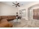 Open-concept living room with an inviting tan sofa, modern art, and seamless flow to the foyer at 8647 W Lariat Ln, Peoria, AZ 85383