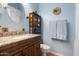 Bathroom featuring vanity with granite top, updated fixtures, round mirror and built-in shelving at 9543 E Kiisa Dr, Scottsdale, AZ 85262