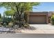 Exterior front of home with desert landscaping and attached garage at 9543 E Kiisa Dr, Scottsdale, AZ 85262
