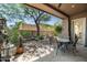 Relaxing covered patio showcasing a stone table set amidst professionally landscaped desert vegetation at 9543 E Kiisa Dr, Scottsdale, AZ 85262