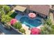 Aerial shot showcases a serene backyard pool surrounded by lush greenery, ample patio space, and shaded umbrellas at 13533 N 91St Way, Scottsdale, AZ 85260