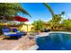 Relaxing poolside view with water feature, comfortable lounge chairs, and lush greenery at 13533 N 91St Way, Scottsdale, AZ 85260