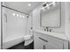 Modern bathroom with white subway tiles, black fixtures, and elegant vanity lighting at 1511 E Carol Ave, Phoenix, AZ 85020