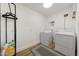 Well-lit laundry room features a washer, dryer, and hanging rack, providing a functional space at 1511 E Carol Ave, Phoenix, AZ 85020