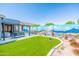 Outdoor patio area with seating, an artificial lawn, and painted mural on the wall, perfect for relaxing and entertaining at 1550 W Saint Kateri Dr, Phoenix, AZ 85041