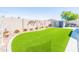Low-maintenance backyard features artificial grass, decorative plants, and a block fence for privacy at 1550 W Saint Kateri Dr, Phoenix, AZ 85041