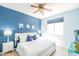Bedroom featuring a ceiling fan, a bed with white bedding and blue pillows, and an adjacent window at 1550 W Saint Kateri Dr, Phoenix, AZ 85041