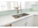 Close up of kitchen sink, white cabinets, countertops, and light blue backsplash at 1550 W Saint Kateri Dr, Phoenix, AZ 85041