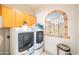 Well-equipped laundry room features a washer and dryer, overhead storage, and desert mural at 1550 W Saint Kateri Dr, Phoenix, AZ 85041