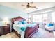 Serene bedroom with a carved wood bed frame, ceiling fan, and bright natural light from windows at 1550 W Saint Kateri Dr, Phoenix, AZ 85041