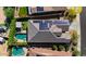 Aerial view of home with a pool, putting green, covered patio and solar panels at 15665 W Coronado Rd, Goodyear, AZ 85395